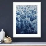 Framed abstract ocean wave painting ‘Deep Blue Sea’ above the commode in a modern living room, featuring rich blues and foam for an elegant touch.