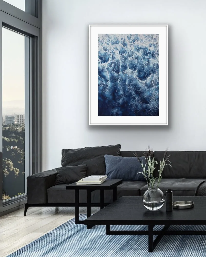 Framed ‘Deep Blue Sea’ abstract ocean painting in a sleek modern living room, featuring waves and foam for a tranquil yet dynamic touch.