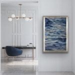 "Evening Mood" watercolor seascape painting framed on a wall in a modern hallway, evoking a tranquil atmosphere with its soft blending of blues and grays. The artwork brings a calming, contemplative mood to the space, inviting a peaceful, ocean-inspired ambiance.
