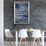 "Evening Mood" framed watercolor seascape in a contemporary dining room, adding serene and calming ocean waves to the modern ambiance with muted blues and grays
