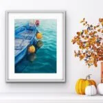 Framed ‘Blue and Yellow Boat’ above a chimney, bringing a calm nautical atmosphere to the room with its tranquil boat and soft water reflections.