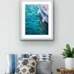 "Summer Memories" watercolor painting of a yacht on calm green water framed in a coastal home, infusing the space with tranquil ocean views.