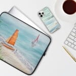 Laptop case with an ocean-inspired ‘Orange Sail’ painting, showcasing a sailboat over calm blue waters—perfect for nautical and coastal laptop accessories.