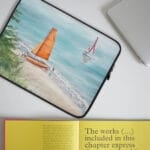 Sleek laptop sleeve featuring ‘Orange Sail’ watercolor art, offering a stylish and serene design for those seeking sailboat and nautical-themed laptop cases.