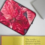 Stylish red poinsettia watercolor painting on laptop case, perfect for festive holiday decor.