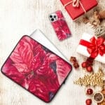 Red poinsettia watercolor artwork on iPhone and laptop cases, festive floral designs perfect for holiday decor and seasonal accessories.