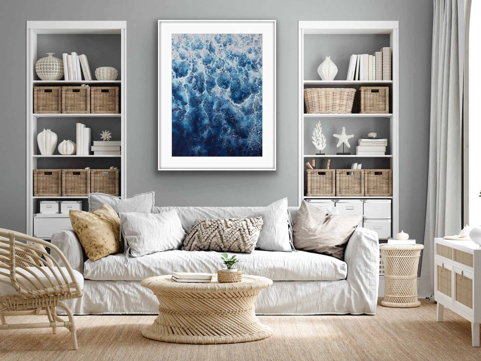 Framed ‘Deep Blue Sea’ painting displayed above a sofa in a coastal living room, showcasing dynamic waves with foam.