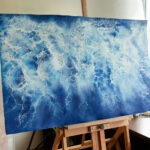 Partially abstract painting 'Ocean Blues' displayed on an easel in the studio, revealing its intricate ocean wave textures and serene color palette during the creation process.