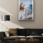 Framed ‘Breaking Wave’ ocean painting in a modern living room above a black sofa.
