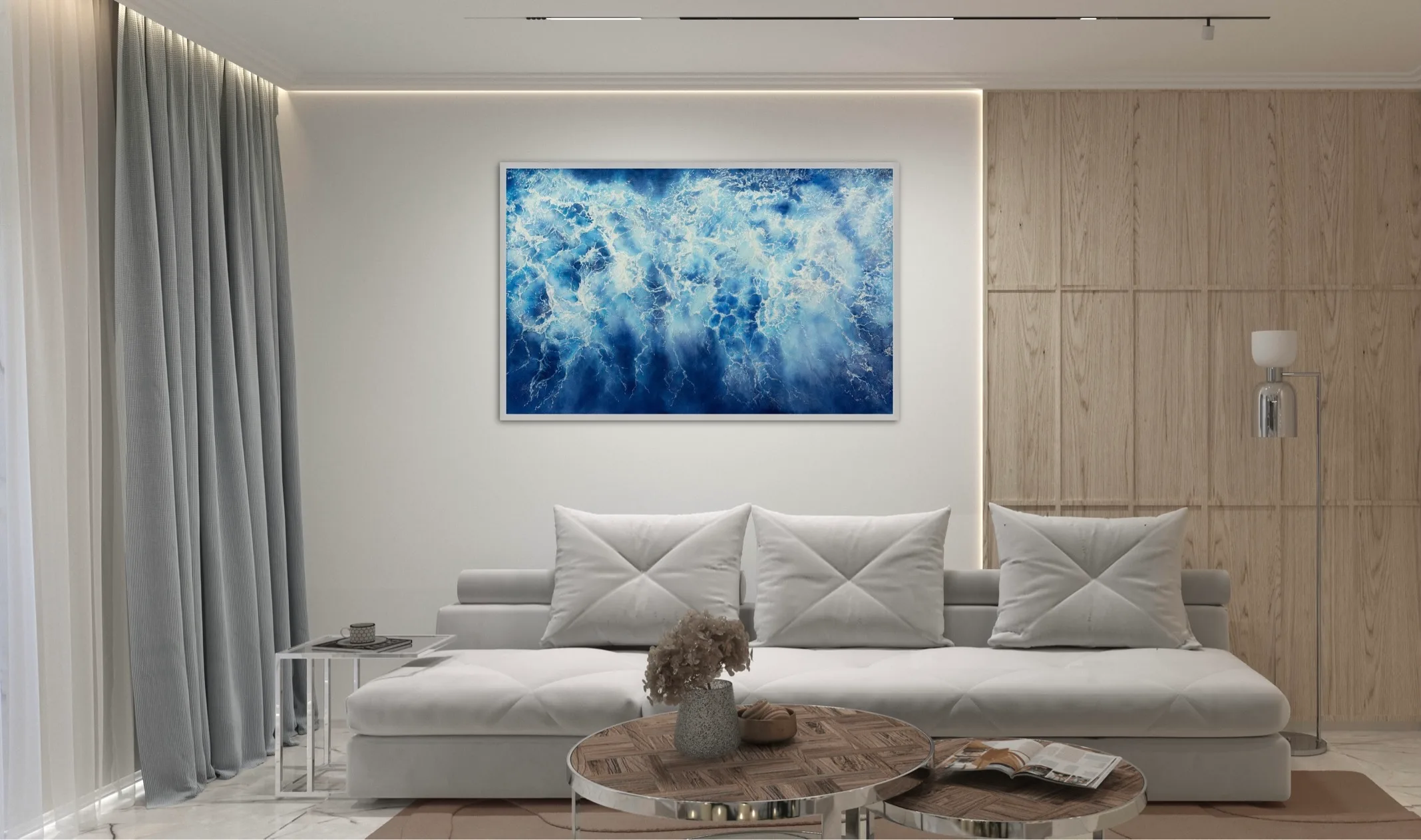Framed 'Ocean Blues' watercolor painting in a modern living room above the sofa.