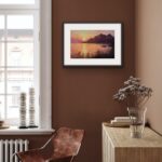 Framed 'Sunset on the Corsica Coast' seascape displayed in a modern living room, enhancing coastal decor.
