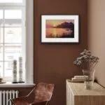 Framed 'Sunset on the Corsica Coast' seascape displayed in a modern living room, enhancing coastal decor.