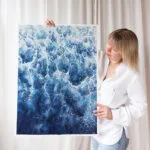 Kateryna Nazarenko with her abstract ocean painting 'Deep Blue Sea,' showing the foam details of the waves.