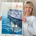 Artist Kateryna Nazarenko holding her original watercolor painting ‘Beginning,’ showcasing a serene yacht at sunrise over calm blue waters.