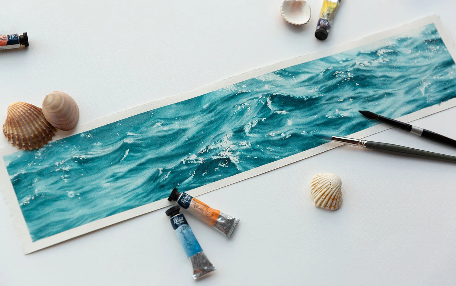 'Sparkles on Turquoise Water' in progress on Kateryna Nazarenko's studio table, with soft watercolor washes blending into vibrant turquoise tones, surrounded by brushes and sketch references.