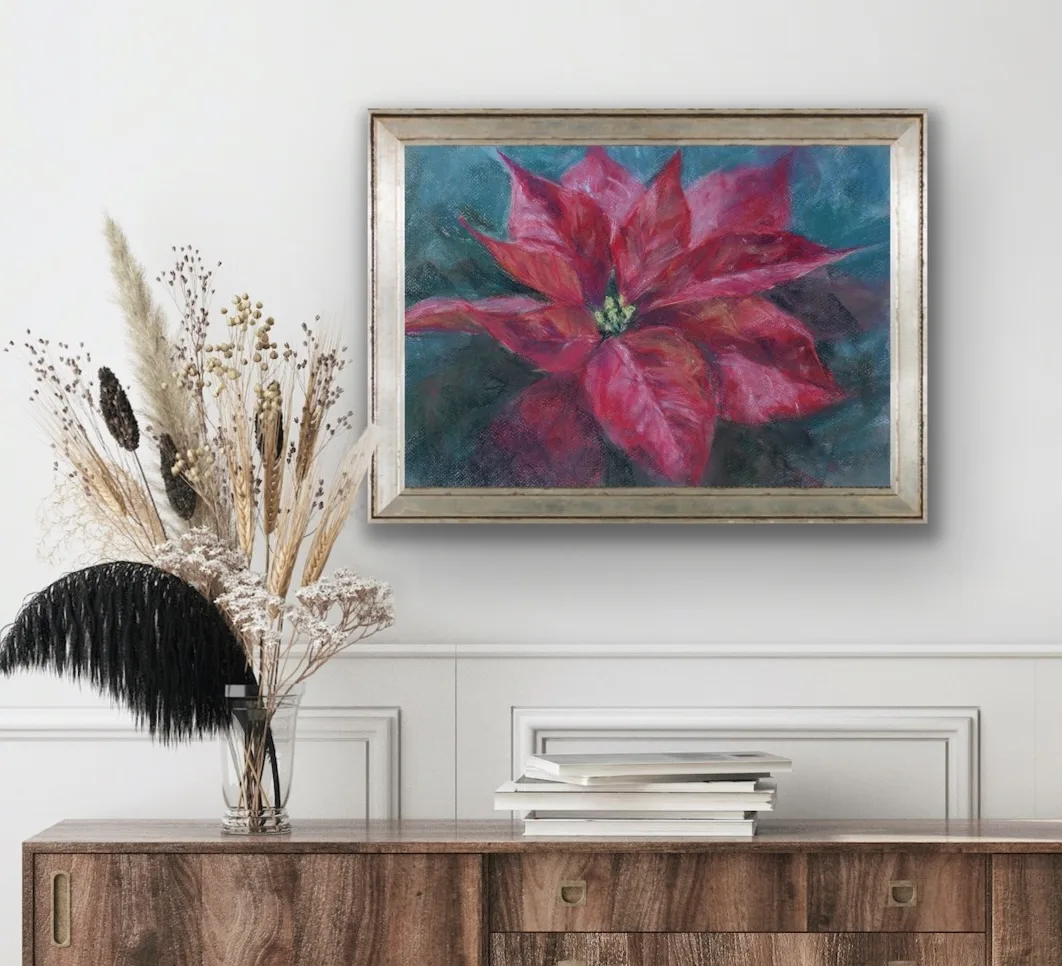 Red poinsettia soft pastel painting above a dresser in a cozy room, adding a vibrant and festive touch to the space.
