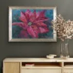 Framed red poinsettia soft pastel painting displayed on a wall, adding elegant holiday charm.