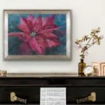 Red poinsettia soft pastel painting displayed above a piano, enhancing the space with vibrant holiday colors and elegance.