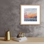 Framed ‘Sunset by the Sea’, adding a peaceful coastal vibe with its warm and calming colors.