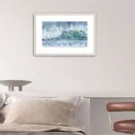 Framed ‘Coastal Wave’ in a cozy bedroom, capturing the calming energy of crashing waves on the beach with rich watercolor hues.