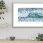 Framed ‘Coastal Wave’ on the wall of a beach house kitchen, perfectly complementing the coastal decor with soothing ocean colors.