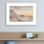 Framed watercolor of Saint-Malo’s coast, featuring dynamic ocean waves crashing under a sunset sky in soft hues.