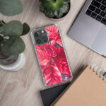 Festive Red Poinsettia MagSafe clear iPhone case on modern office desk, artistic Christmas floral accessory adding seasonal charm to workspaces.