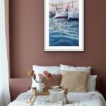Framed ‘Morning in the Port’ in a minimalist bedroom, adding a serene nautical touch with its calming blue hues.
