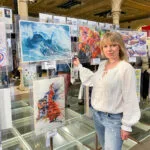 Artist Kateryna Nazarenko with her watercolor seascape painting Fragile but Strong on the FabrianoInAcquarello 2023 exhibition