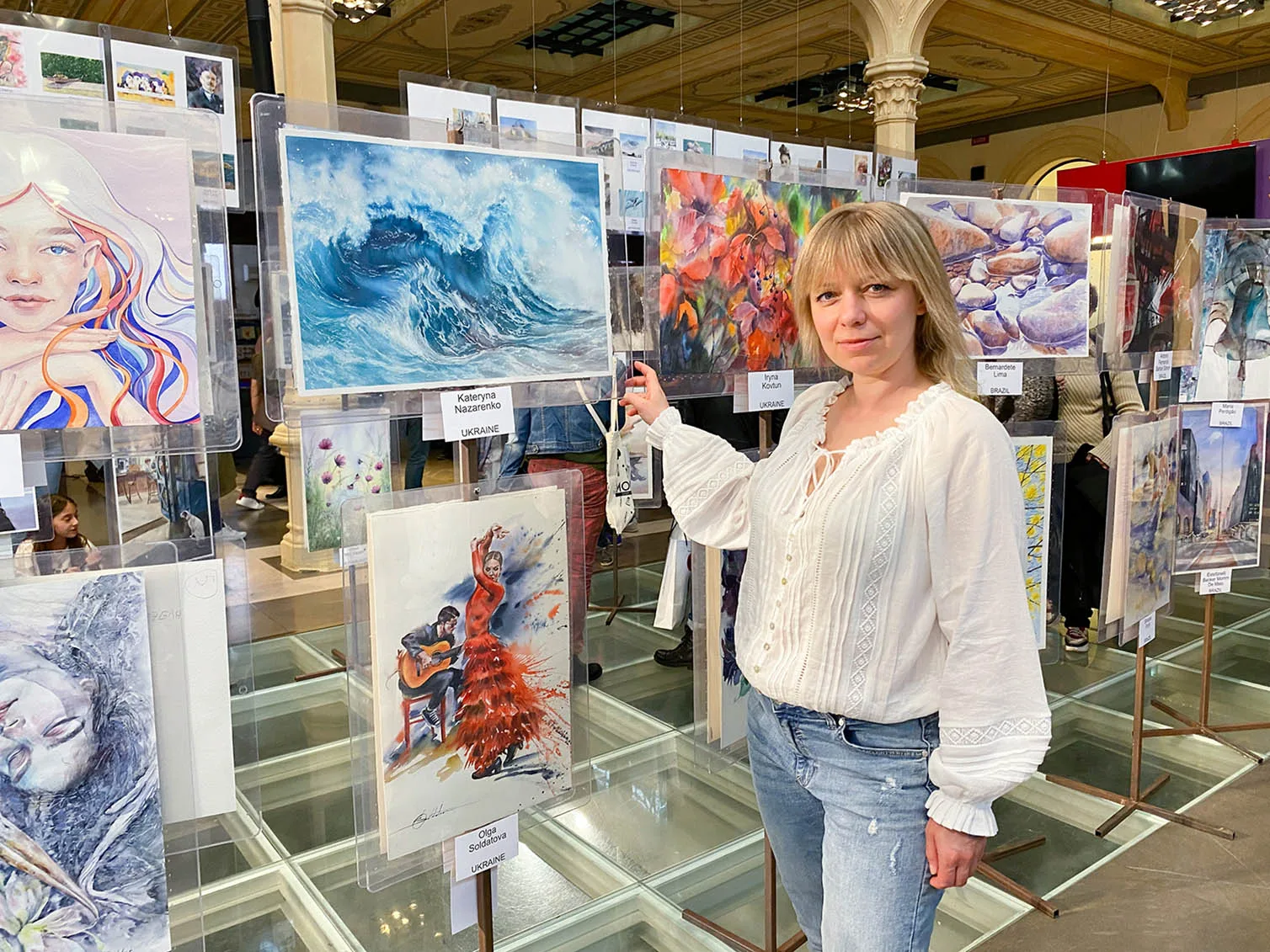 Artist Kateryna Nazarenko with her watercolor seascape painting Fragile but Strong on the FabrianoInAcquarello 2023 exhibition