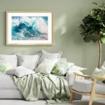 "Fragile but Strong" ocean wave watercolor painting elegantly displayed above a sofa in a coastal home, enhancing the serene and nautical-inspired interior.