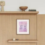 Watercolor painting "Sailboats at Pink Sunset" by Kateryna Nazarenko hanging in a bedroom interior, adding a calming atmosphere with its pastel tones and tranquil nautical scene.