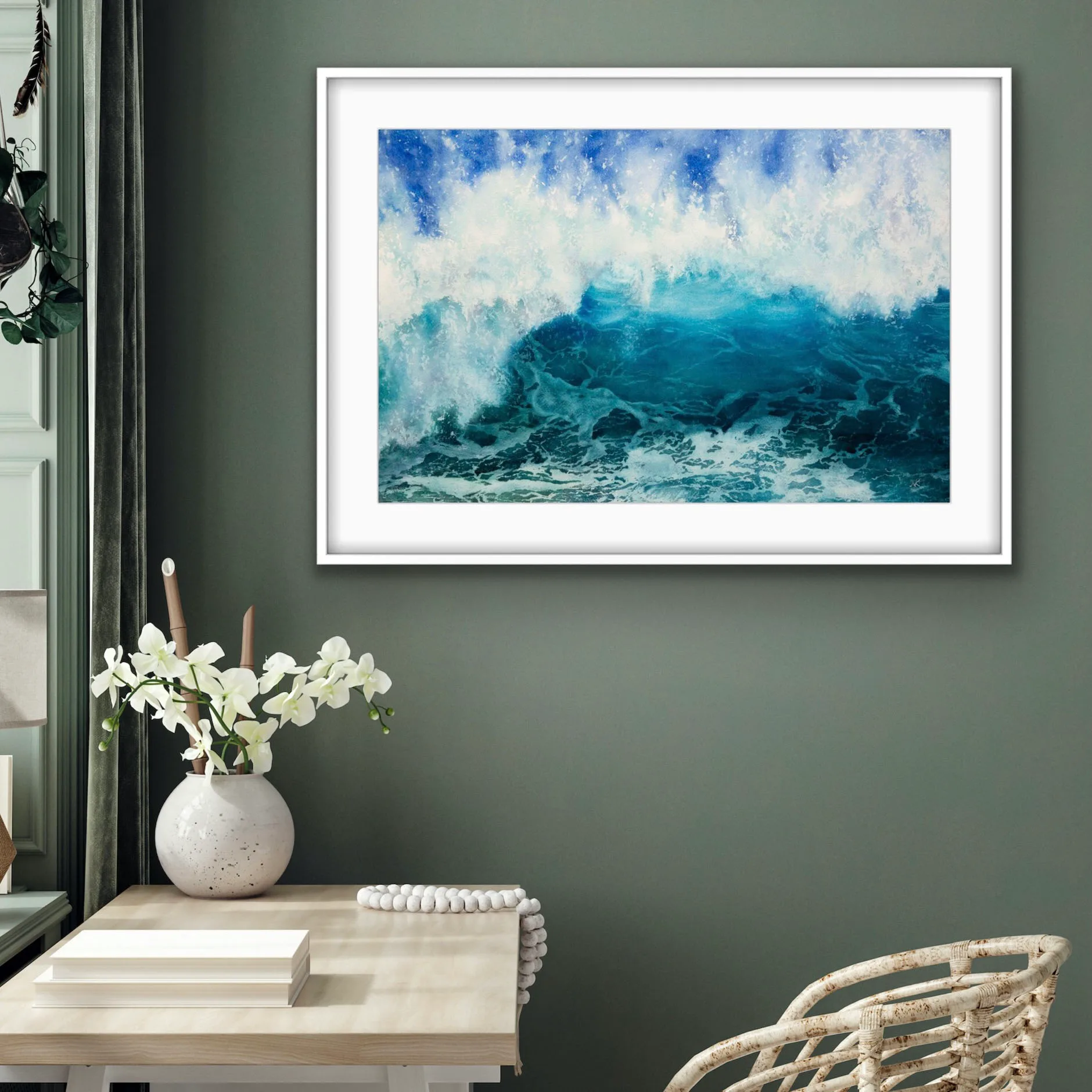 Framed 'Through the Light' watercolor painting in a home study, depicting the dynamic energy of the ocean with a rising wave in deep blues and turquoise, bringing a calming yet powerful coastal atmosphere to the workspace.