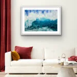 Through the Light’ framed watercolor painting above a sofa in a cozy living room, featuring dynamic waves and ocean motion in vibrant blues and turquoise, complementing the room’s coastal-inspired decor with energy and tranquility.