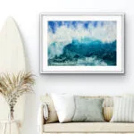 ‘Through the Light’ original watercolor painting above the sofa in a coastal home, depicting dynamic ocean waves with shades of deep blue, turquoise, and sunlight foam, enhancing the serene coastal atmosphere and adding a sense of movement and tranquility to the room.
