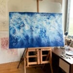 Original ocean watercolor painting on easel by Kateryna Nazarenko – tranquil abstract seascape artwork in blue, ideal for coastal interior decor, nautical wall art, and ocean-themed gift ideas.