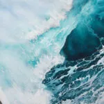 Focused detail of ocean foam, capturing dynamic white spray from the wave.
