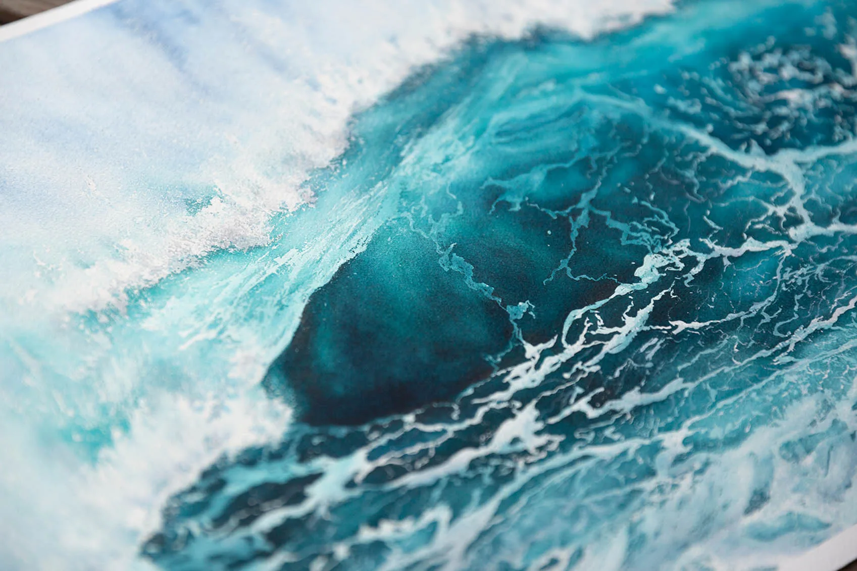 Close-up of ocean wave spray with frothy white foam and blue tones.