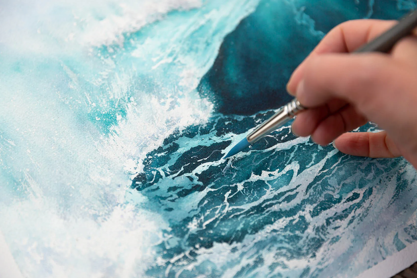 Artist's painting process with watercolor brushes and paint on the artwork.