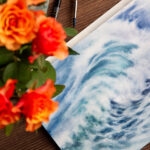 Whispering Wave watercolor painting in progress, showcasing delicate brushstrokes as layers of ocean blues and misty white foam come to life in the artist’s studio.