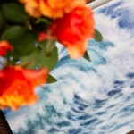 Whispering Wave original seascape watercolor displayed in an artist’s studio, capturing the rhythmic motion of the sea with soft blues and misty white foam.