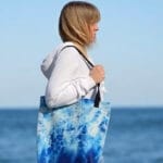 Artist Kateryna Nazarenko posing with her Blue Ocean Tote Bag, showcasing a unique watercolor ocean waves design – a must-have coastal fashion accessory for sea lovers, art enthusiasts, and those who appreciate ocean-inspired style.