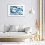 White and airy living room with framed ocean art print, Blue Ocean Whisper watercolor adds marine tranquility and modern coastal aesthetic.