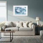 Large sofa in beach house living room with Blue Ocean Whisper fine art print, elegant abstract seascape enhancing relaxing ocean theme.