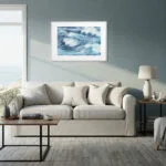 Large sofa in beach house living room with Blue Ocean Whisper fine art print, elegant abstract seascape enhancing relaxing ocean theme.