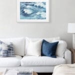 Sunlit coastal living room with framed seascape print Blue Ocean Whisper, soft ocean tones in blue and white for ocean lovers’ interiors.