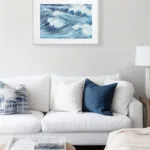 Sunlit coastal living room with framed seascape print Blue Ocean Whisper, soft ocean tones in blue and white for ocean lovers’ interiors.