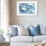 Living room with ocean-inspired print "Blue Ocean Whisper," abstract waves in soft blue, modern sea wall art for beach house interiors.