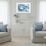 Framed Blue Ocean Whisper in light wood interior, modern ocean painting for coastal living room, soft wave movement and sea-inspired tones.