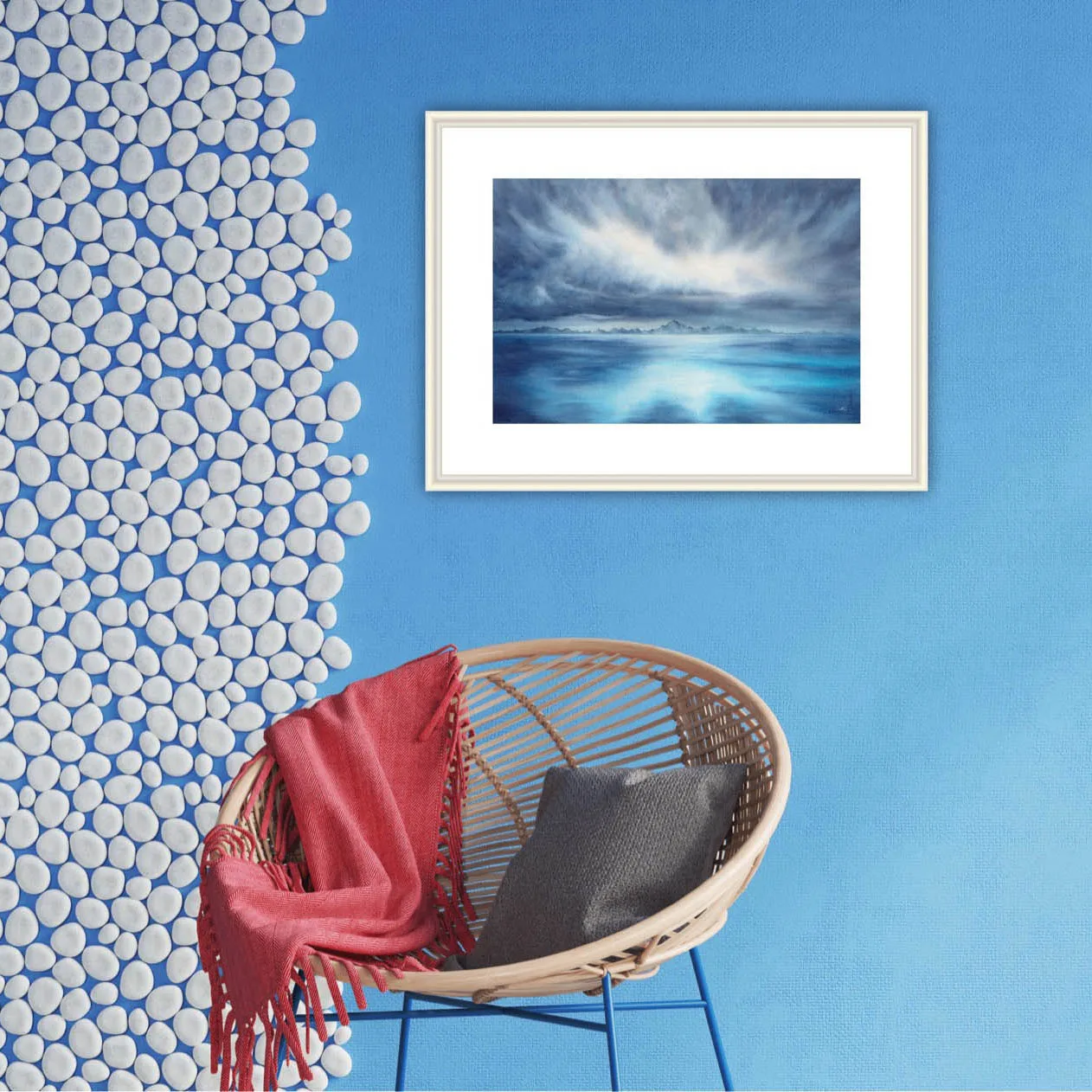 "Where Storm Meets Light" fine art print of a stormy sea watercolor painting displayed in a coastal interior. This blue ocean wall art adds a dynamic and calming element to the space, blending seamlessly with the light, airy decor and marine-inspired accents for a serene seascape focal point.